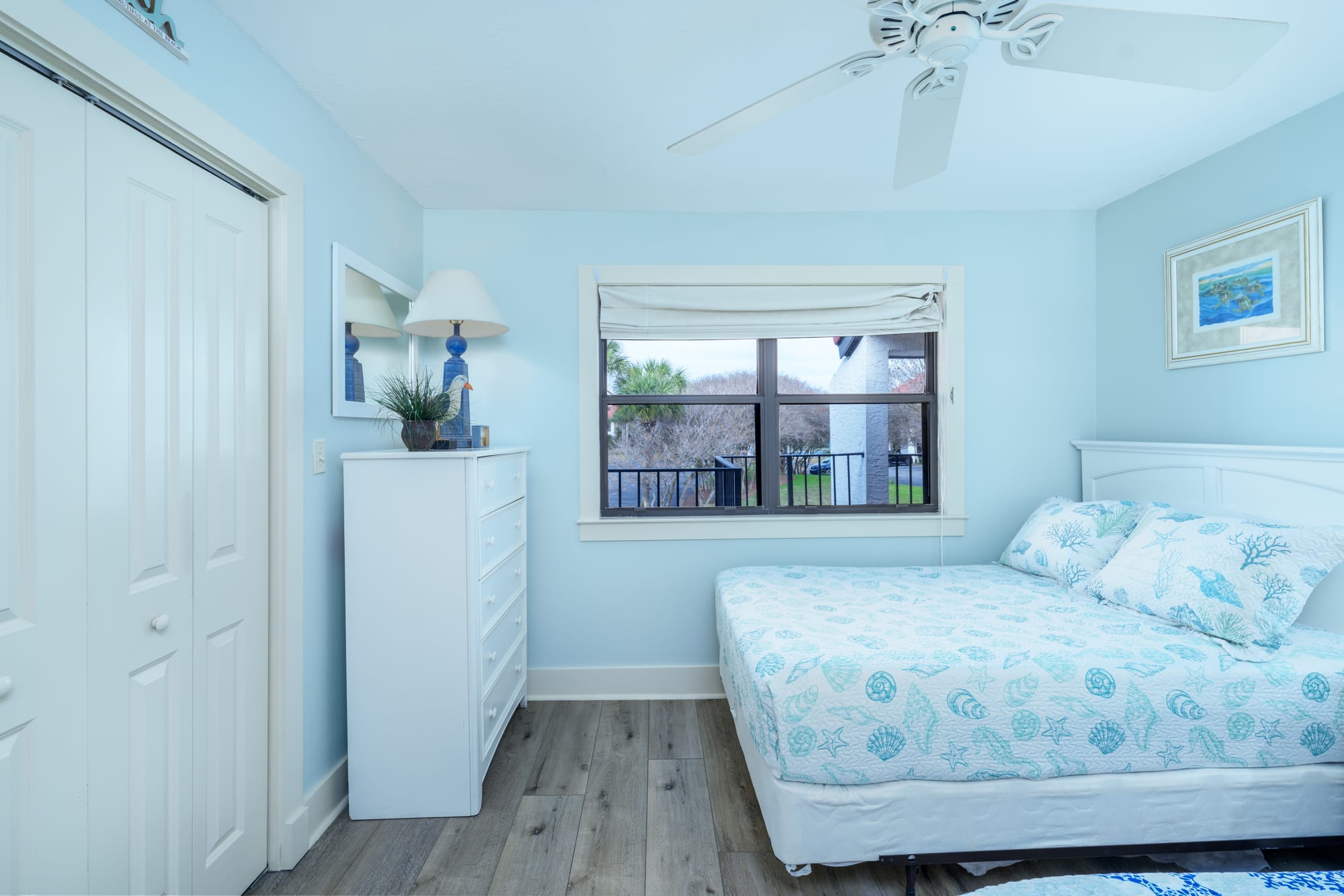 Second bedroom with a dresser, closet doors, and one of the full beds.