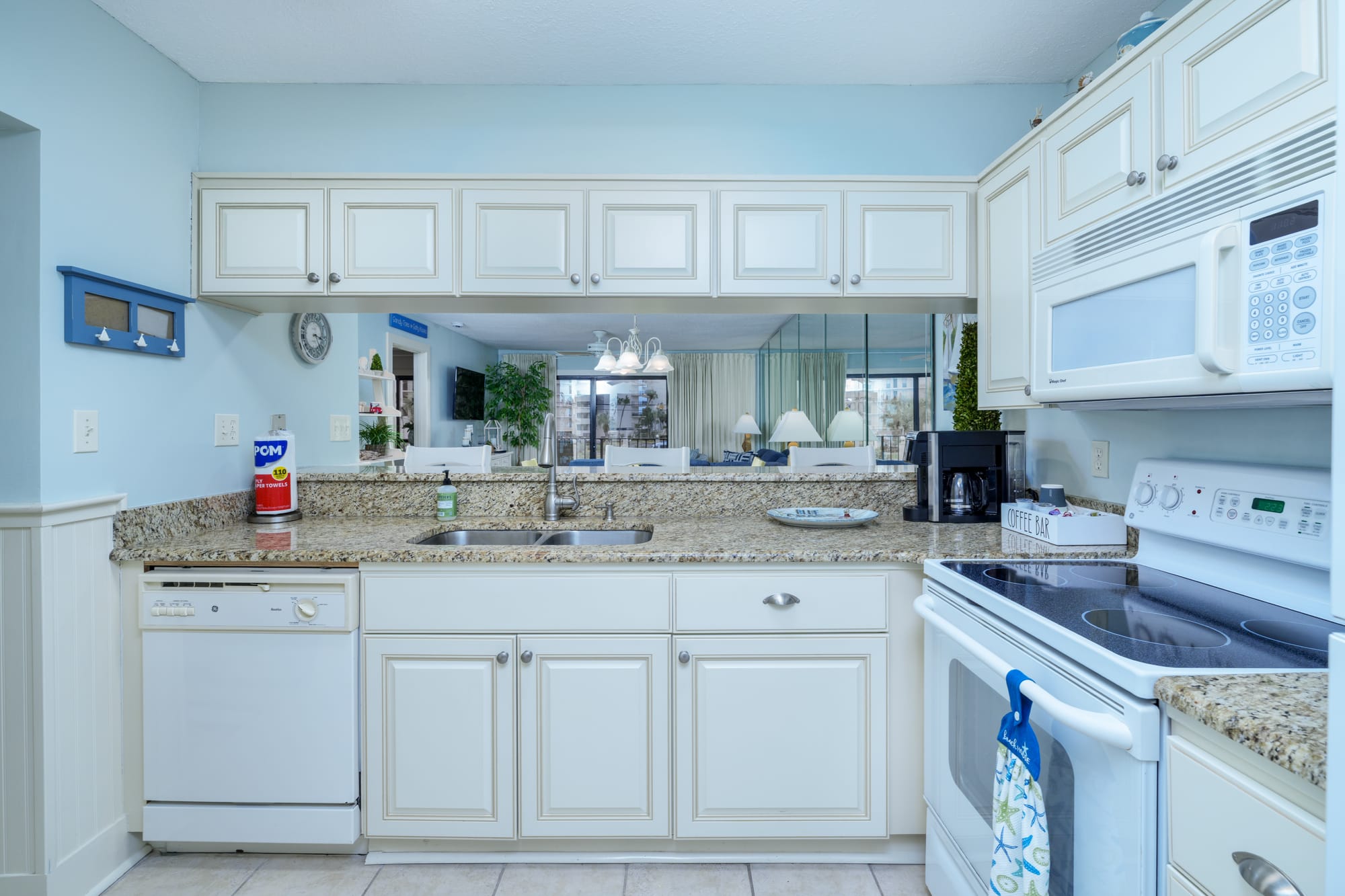 Kitchen counters with a dishwasher, double sink, electric range, and microwave.