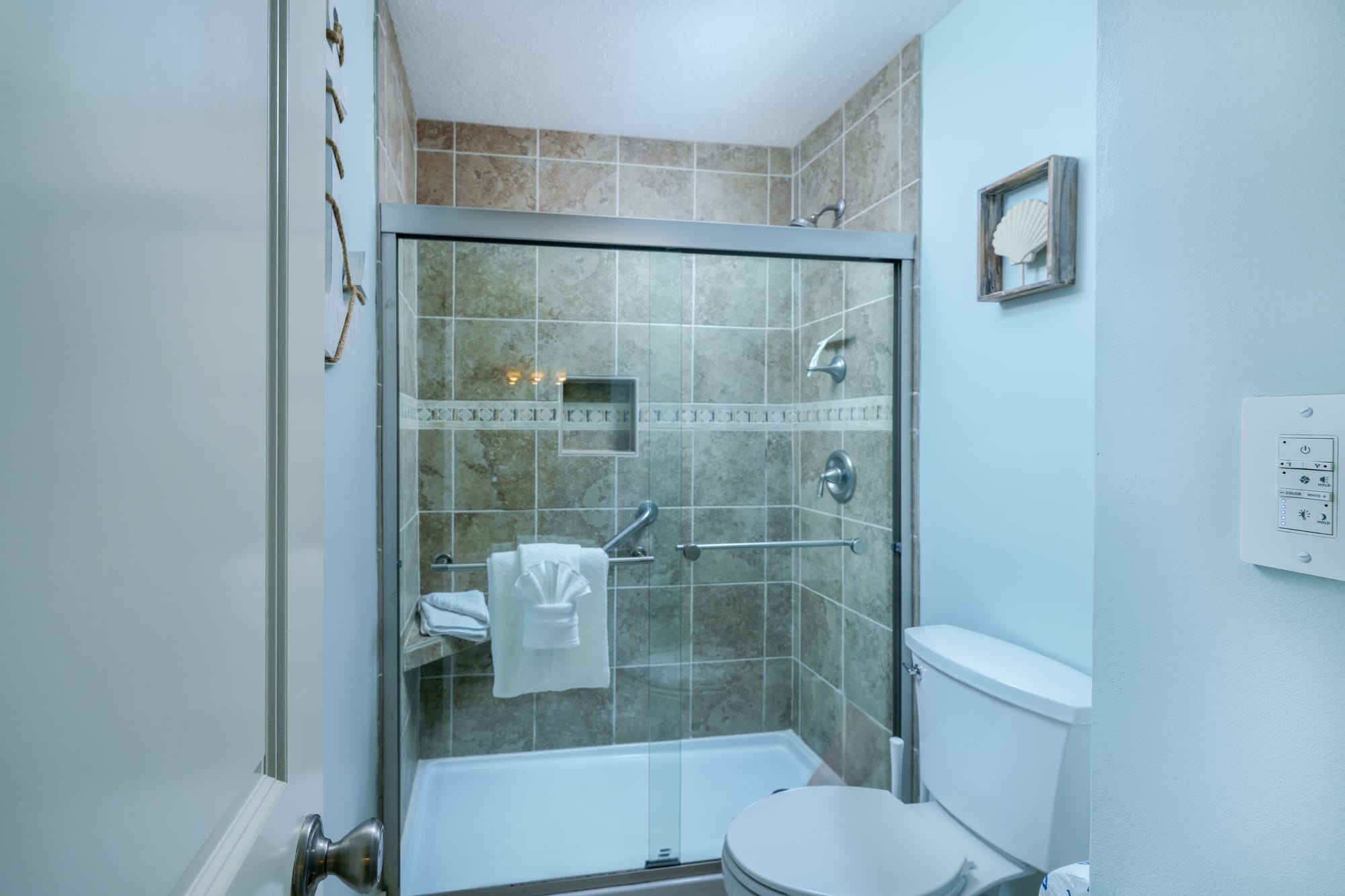 Primary bathroom with a tiled walk-in shower and a toilet.